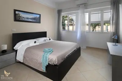 a bedroom with a bed and a desk and windows at Garden and Relax in Rome