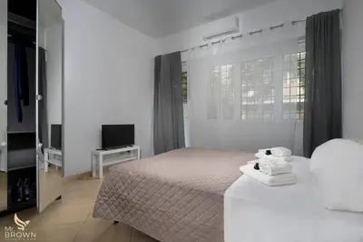 a white bedroom with a bed and a television at Garden and Relax in Rome