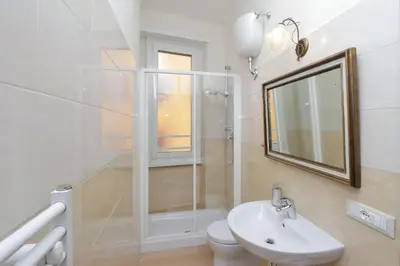 a bathroom with a shower and a sink and a mirror at Apartment Marrucini in Rome