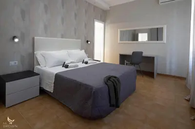 a bedroom with a bed with a desk and a chair at San Paolo Superior Room in Rome