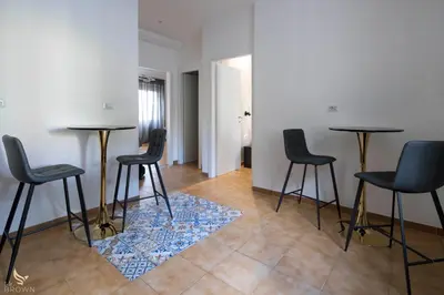 a room with three tables and chairs and a rug at San Paolo Superior Room in Rome