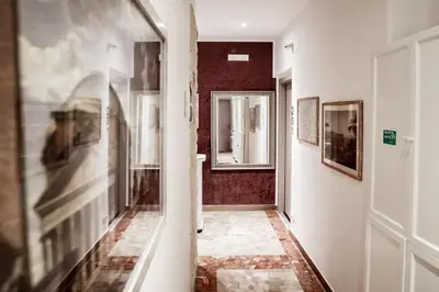 a hallway with a mirror and paintings on the walls at Relais Circo Massimo in Rome