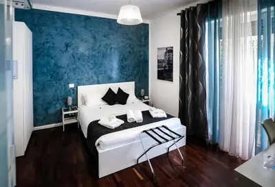 a bedroom with a white bed and a blue wall at Relais Circo Massimo in Rome