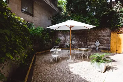 a patio with a table and chairs and an umbrella at Relais Circo Massimo in Rome