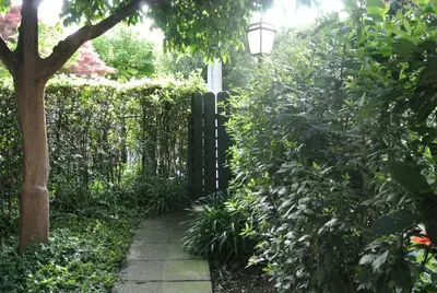 a garden with a gate and a walkway at Appartamento Garden Palatino in Rome