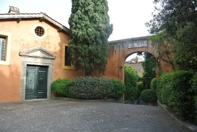 a building with a green door and an archway at Appartamento Garden Palatino in Rome