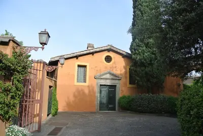 a orange house with a door and a fence at Appartamento Garden Palatino in Rome