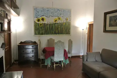 a living room with a table and a painting on the wall at Appartamento Garden Palatino in Rome
