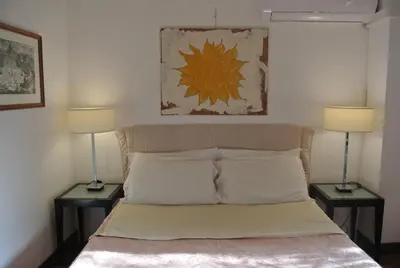 a bedroom with a bed with two lamps on both sides at Appartamento Garden Palatino in Rome