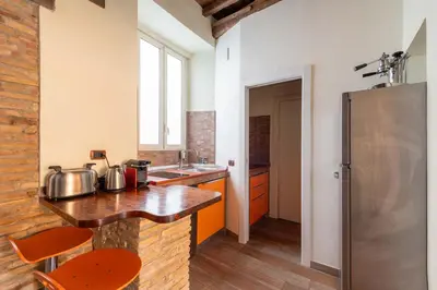 a kitchen with a wooden counter and a refrigerator at Maison Leo a Largo Argentina in Rome