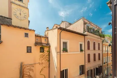 a building with a clock tower in a city at Maison Leo a Largo Argentina in Rome
