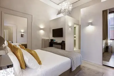 a bedroom with a white bed and a chandelier at Terrace Pantheon Relais in Rome