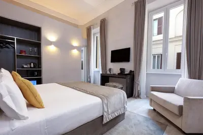 a bedroom with a bed and a chair and a television at Terrace Pantheon Relais in Rome