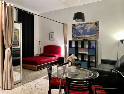 a living room with a glass table and a red couch at Spacious Studio in Via dei Coronari in Rome