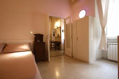 a bedroom with a bed and a window and a table at Manara Holiday House in Rome
