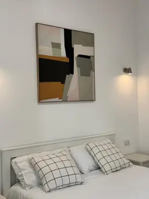 a bed with two pillows and a painting above it at Flat 7 Rome Guesthouse in Rome