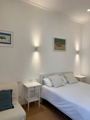 a bedroom with two beds and a table and a couch at Flat 7 Rome Guesthouse in Rome