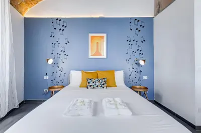 a bedroom with a blue wall and a large bed at FaMa - Le Volte in Rome