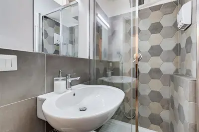a white bathroom with a sink and a shower at FaMa - Le Volte in Rome