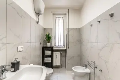 a white bathroom with a sink and a toilet at Vatican Cartographer in Rome