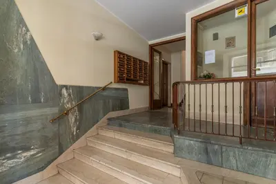 a staircase in a home with wooden railings and a wall at Vatican Cartographer in Rome