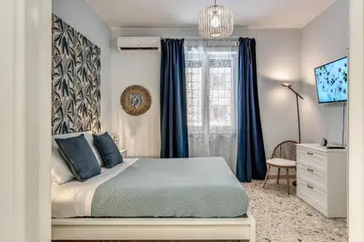 a bedroom with a bed and a window with blue curtains at Vatican Cartographer in Rome
