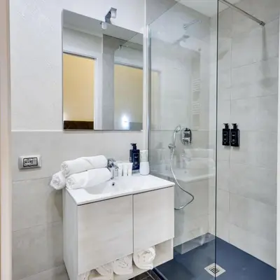 a white bathroom with a sink and a shower at V Collection Rome Jubilee Guest House in Rome