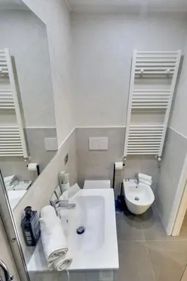 a bathroom with a white sink and a toilet at V Collection Rome Jubilee Guest House in Rome