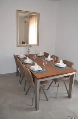 a long wooden table with chairs and a mirror at Casa Erminia in Rome
