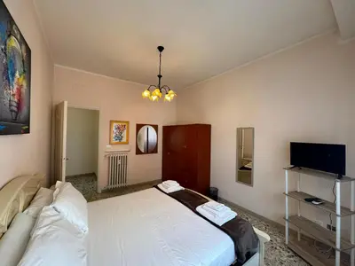 a bedroom with a white bed and a flat screen tv at Vintage Charm Apt in Aurelio in Rome