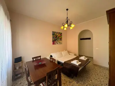 a living room with a bed and a dining room table at Vintage Charm Apt in Aurelio in Rome