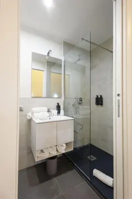 a bathroom with a sink and a glass shower at V Collection Vatican Jubilee Guest House in Rome