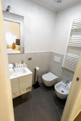 a bathroom with a sink and a toilet and a mirror at V Collection Vatican Jubilee Guest House in Rome