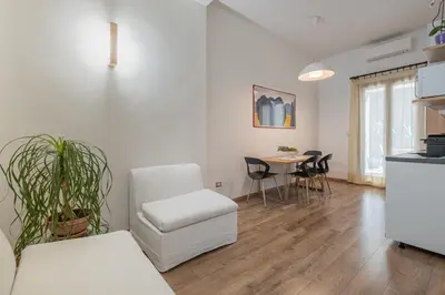a white living room with a table and chairs at LE TRE M - Guesthouse in Rome