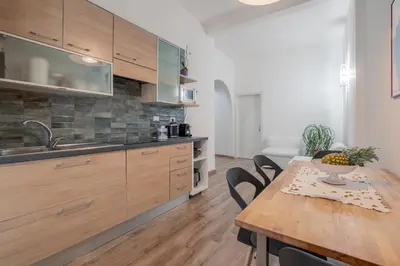 a kitchen with wooden cabinets and a wooden table at LE TRE M - Guesthouse in Rome