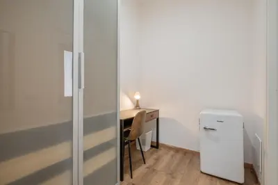 a room with a desk and a white refrigerator at LE TRE M - Guesthouse in Rome