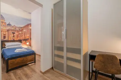 a bedroom with a bed and a desk and a table at LE TRE M - Guesthouse in Rome
