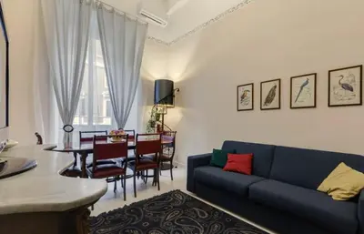 a living room with a blue couch and a dining room at Domus Ottavia in Roma in Rome