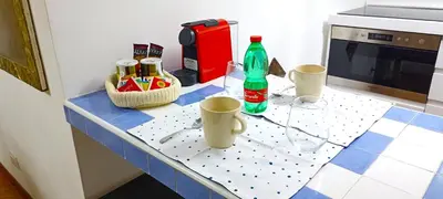 a kitchen counter with a table with bottles and cups at Colosseo Dream in Rome