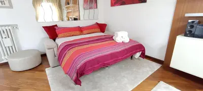 a small bedroom with a bed with a colorful blanket at Colosseo Dream in Rome