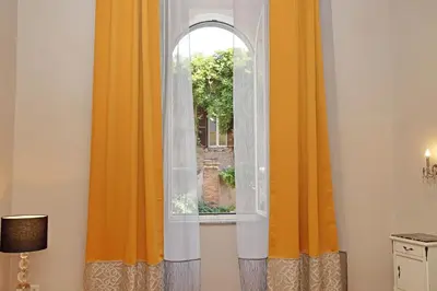 an open window with orange curtains in a room at dolce casa colosseo 2 in Rome