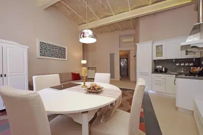 a kitchen and dining room with a white table and chairs at dolce casa colosseo 2 in Rome