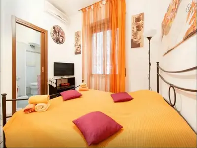 a bedroom with a large yellow bed with purple pillows at San Giovanni In Laterano Daniela Apartment in Rome