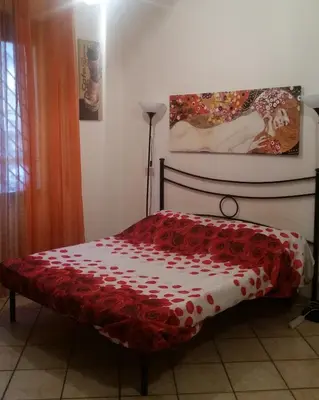 a bedroom with a bed with a red and white cover at San Giovanni In Laterano Daniela Apartment in Rome
