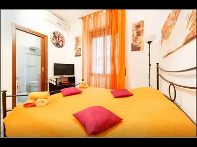 a bedroom with a large yellow bed with red pillows at San Giovanni In Laterano Daniela Apartment in Rome