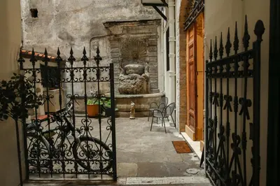 an entrance to a courtyard with a gate and a fountain at Casa Cavour in Rome