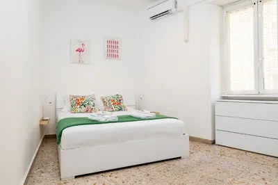a white bedroom with a bed in a white room at Pandolfo Apartment in Rome