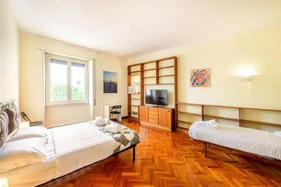 a large room with two beds and a television at Viale Mazzini Big Apartment in Rome