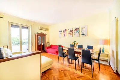 a living room with a table and chairs and a red couch at Viale Mazzini Big Apartment in Rome