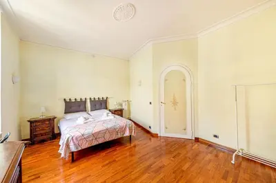 a bedroom with a bed and a wooden floor at Viale Mazzini Big Apartment in Rome